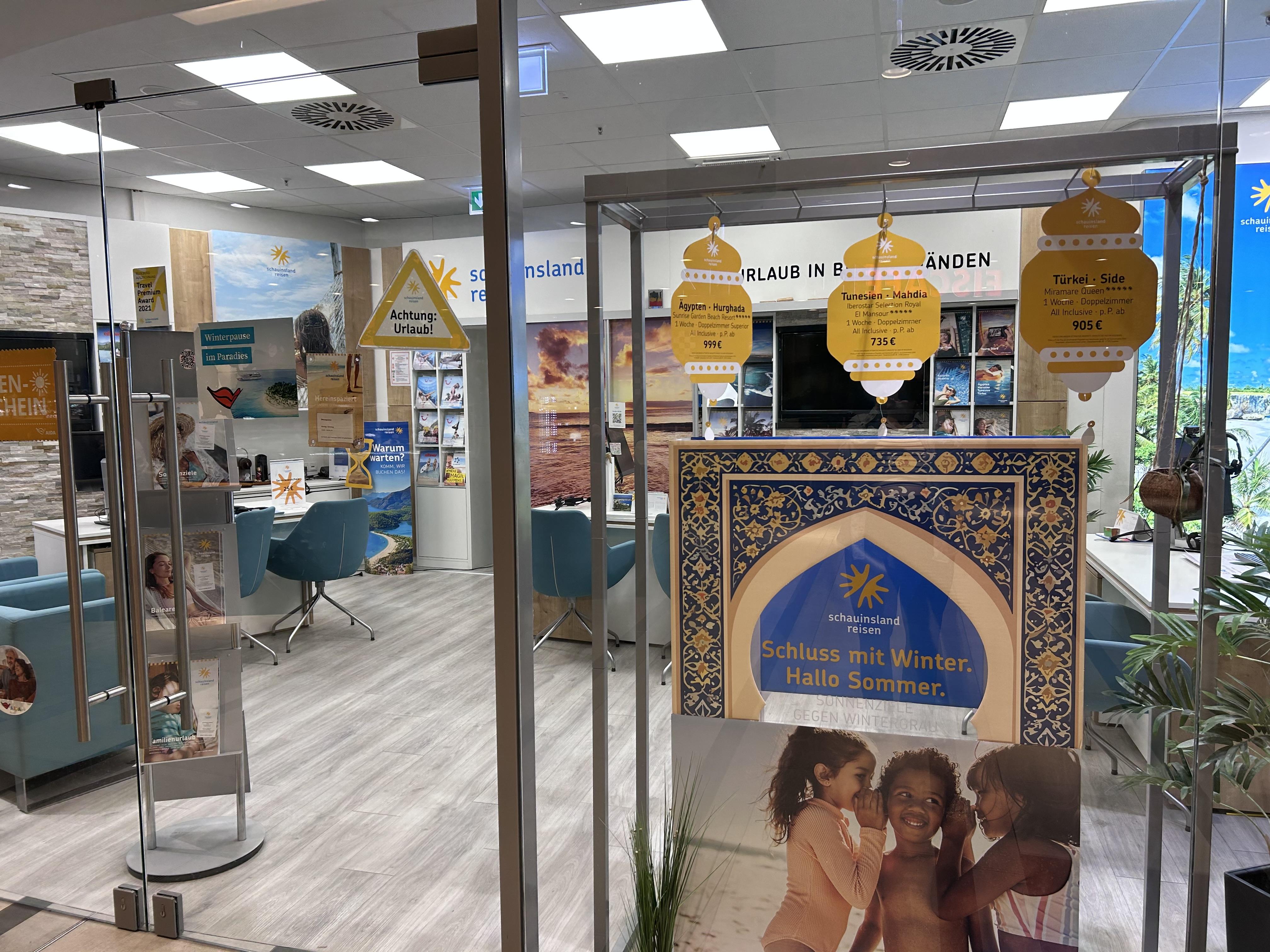 Reisebüro mit hellen Räumen, bunten Postern und Beratungstischen für Urlaubsplanung und Hotels.