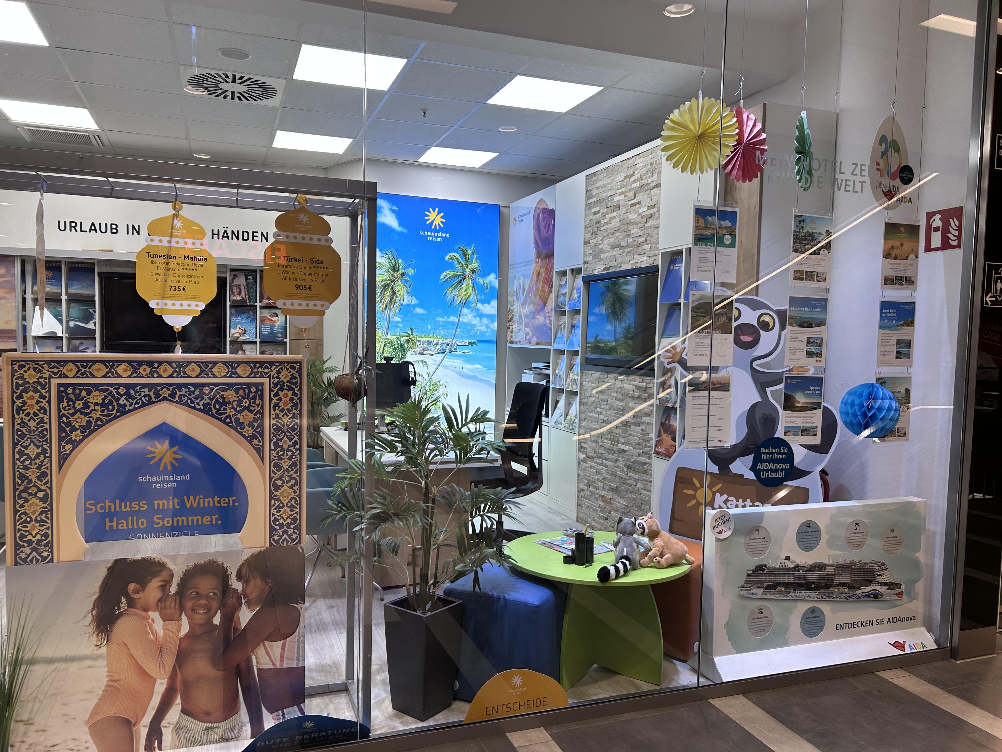 Reisebüro mit bunten Dekorationen, Strandbildern und Urlaubsmotiven, einladend für Ferienplanung.