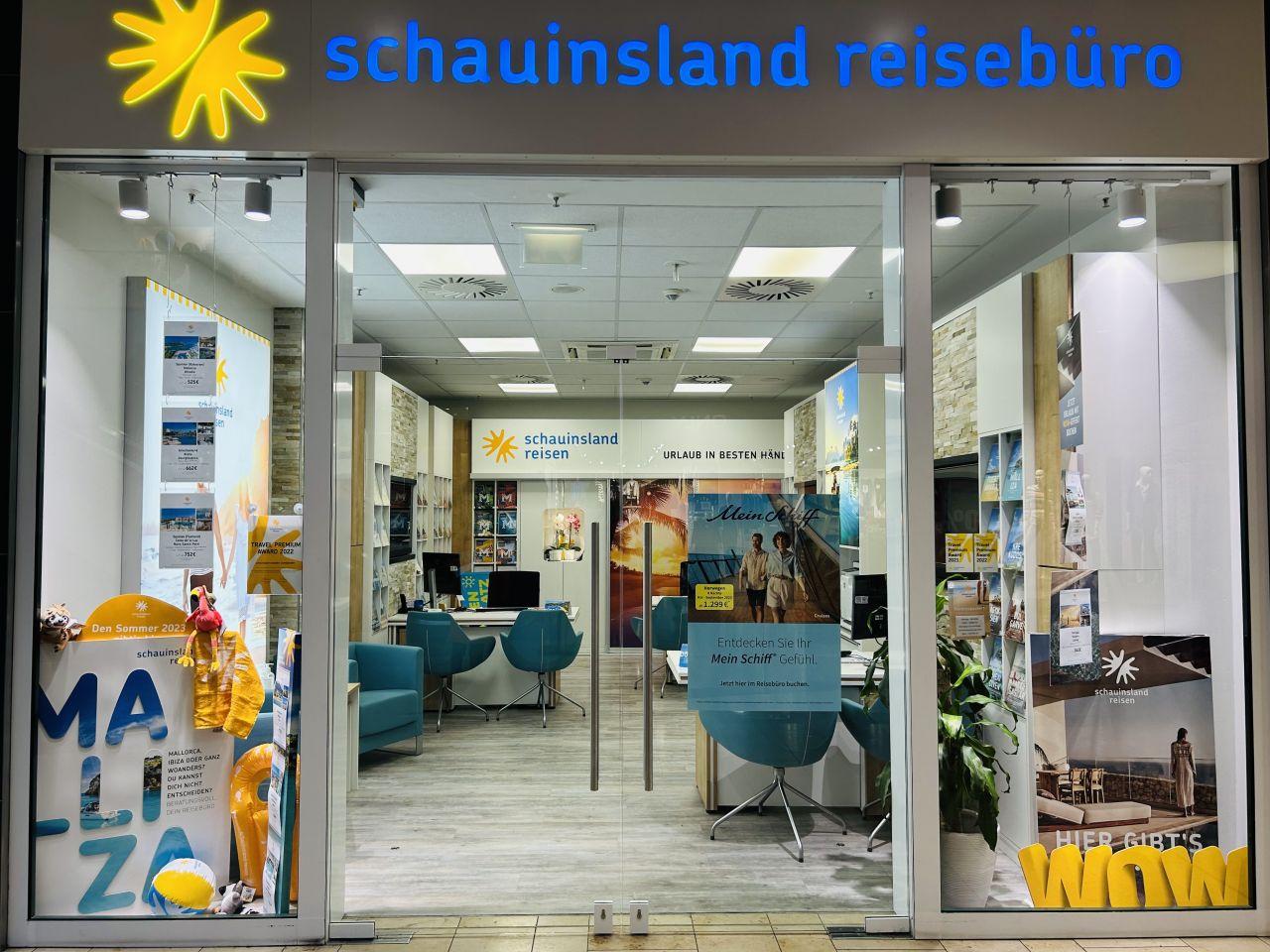 Hell beleuchtetes Reisebüro mit moderner Einrichtung, blau-gelben Farbakzenten und Werbematerialien zu Urlaubszielen.