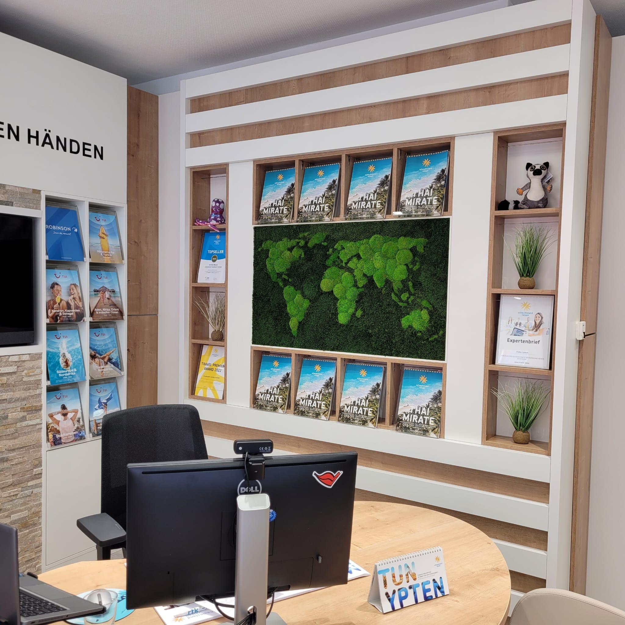 Moderner Reisebüro-Schalter mit Reiseführern, Pflanzen und Weltkarten-Wanddekor für Urlaubsplanung.