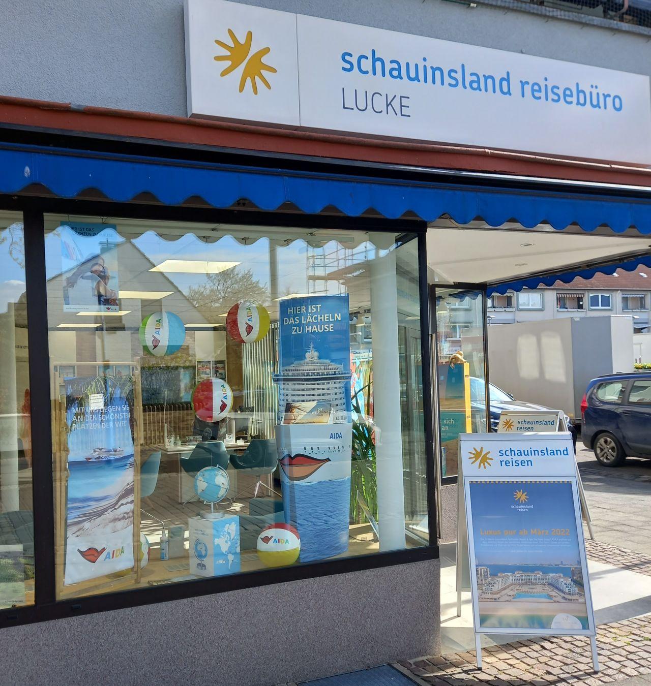 Reisebüro mit blauer Markise und Werbepostern lädt zu Urlaub und Ferien an sonnigen Stränden ein.